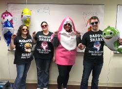 Bank employees dressed up as baby shark, daddy shark, mommy shark, and auntie shark